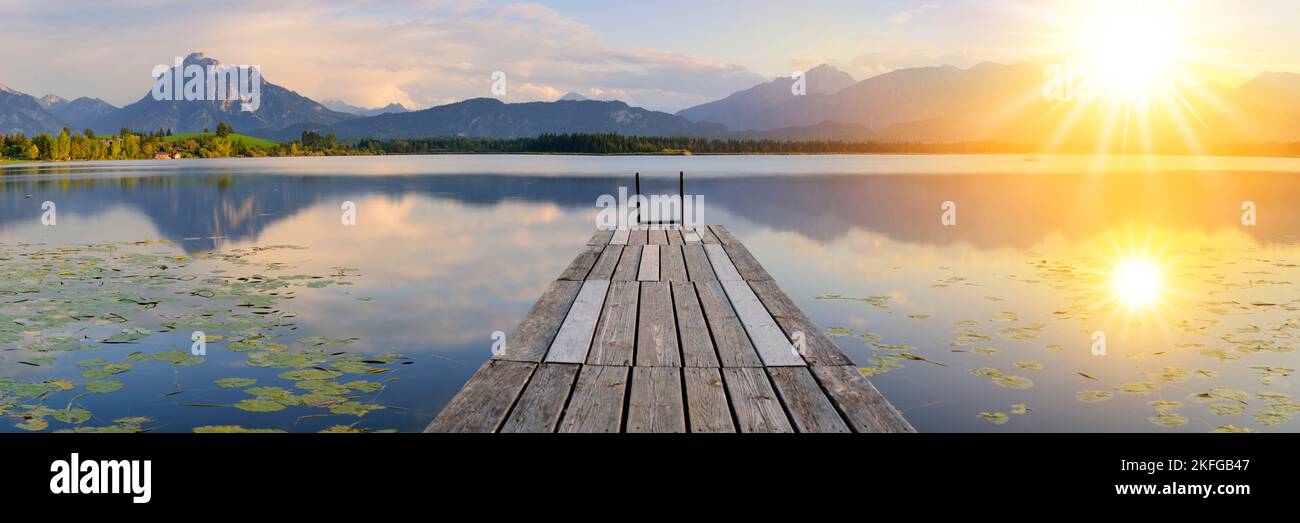 Panoramic landscape at the lake with jetty and sunset Stock Photo
