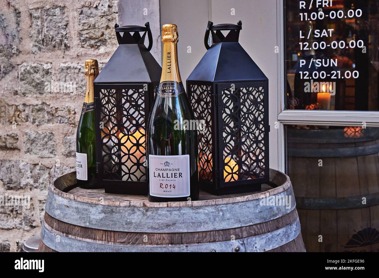 Lanterns with candles and bottles of champagne on wooden barrel for