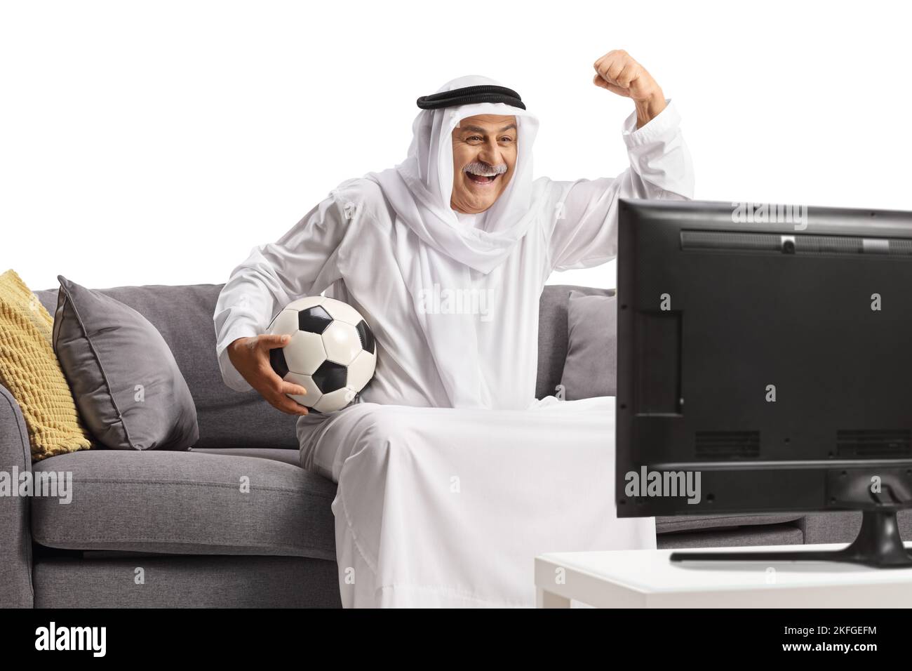 Mature arab man in a robe holding a football and cheering seated on a ...
