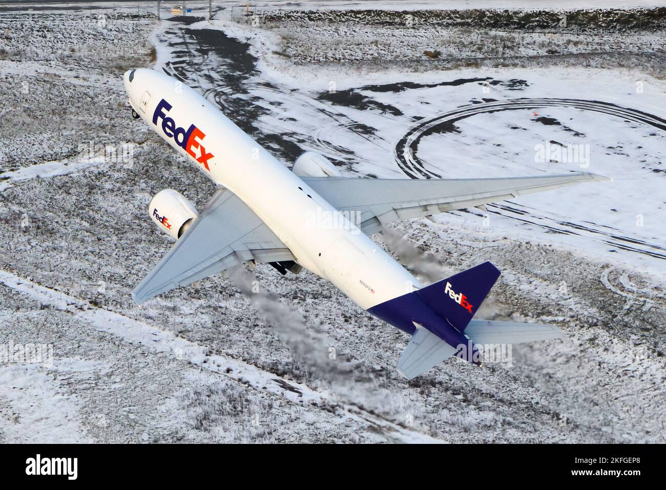 Fedex Boeing 777 aircraft departing in winter. Airplane 777F for cargo transport with Federal Express taking off. Plane departing seen from above. Stock Photo