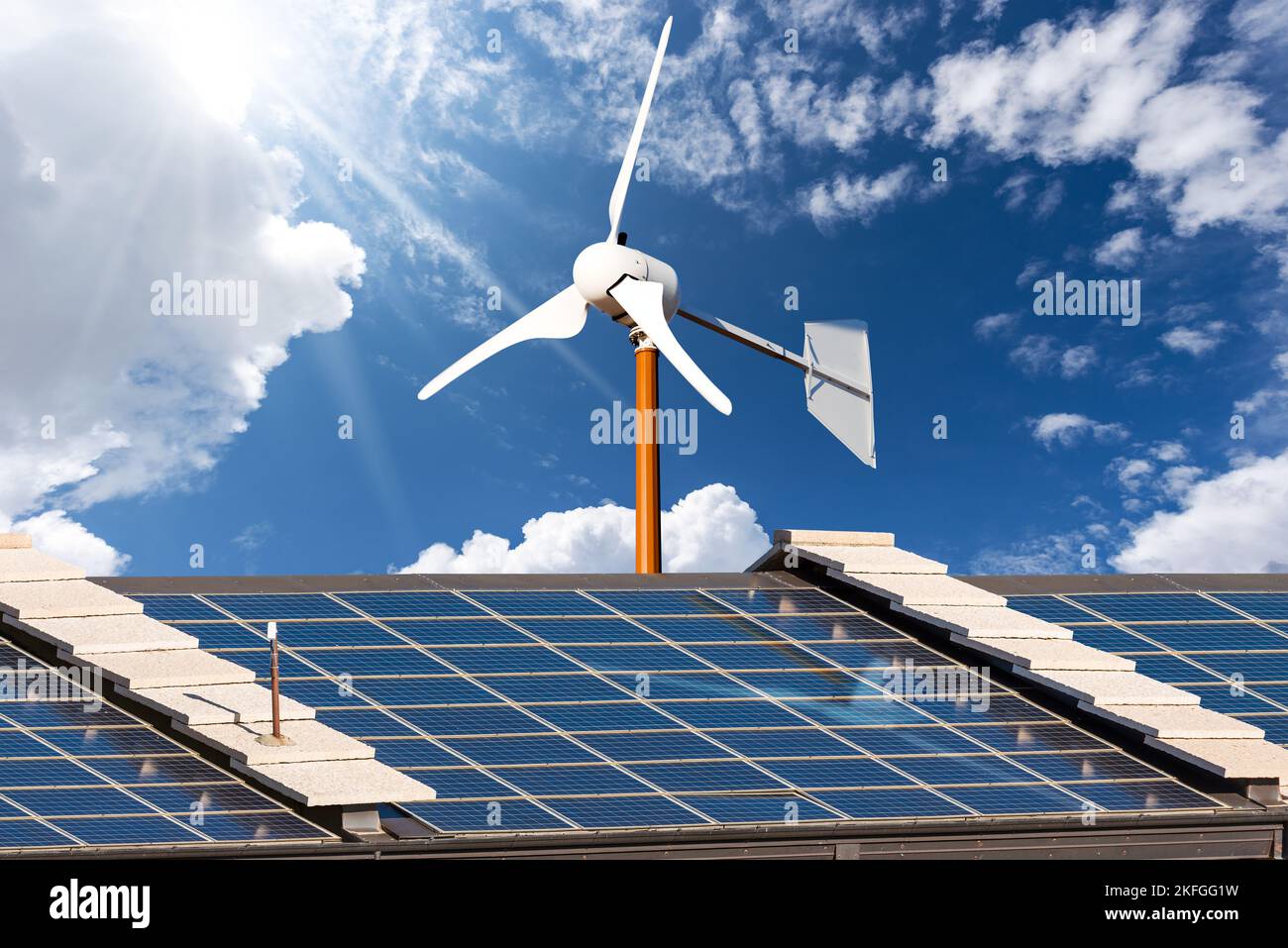 Close-up of a roof with many solar panels and a small wind turbine ...
