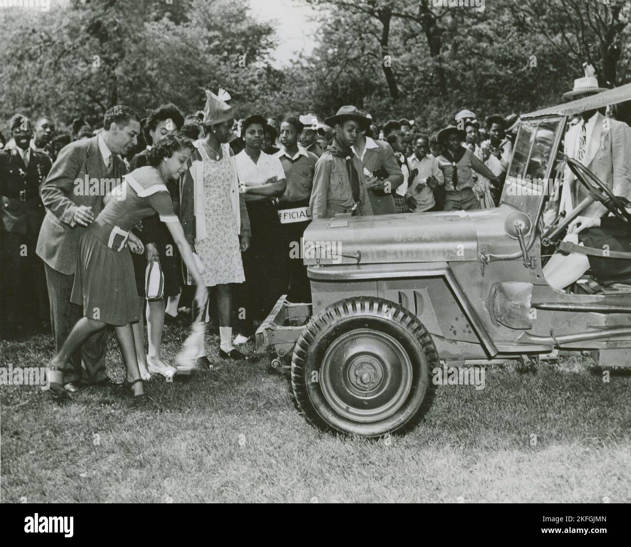 Chicago school children buy $263,148.83 in war bonds, (1942 - 1943?). African American schoolgirl christening one of the jeeps in the War Bond Rally in Washington Park on June 4, Chicago, Illinois. Stock Photo