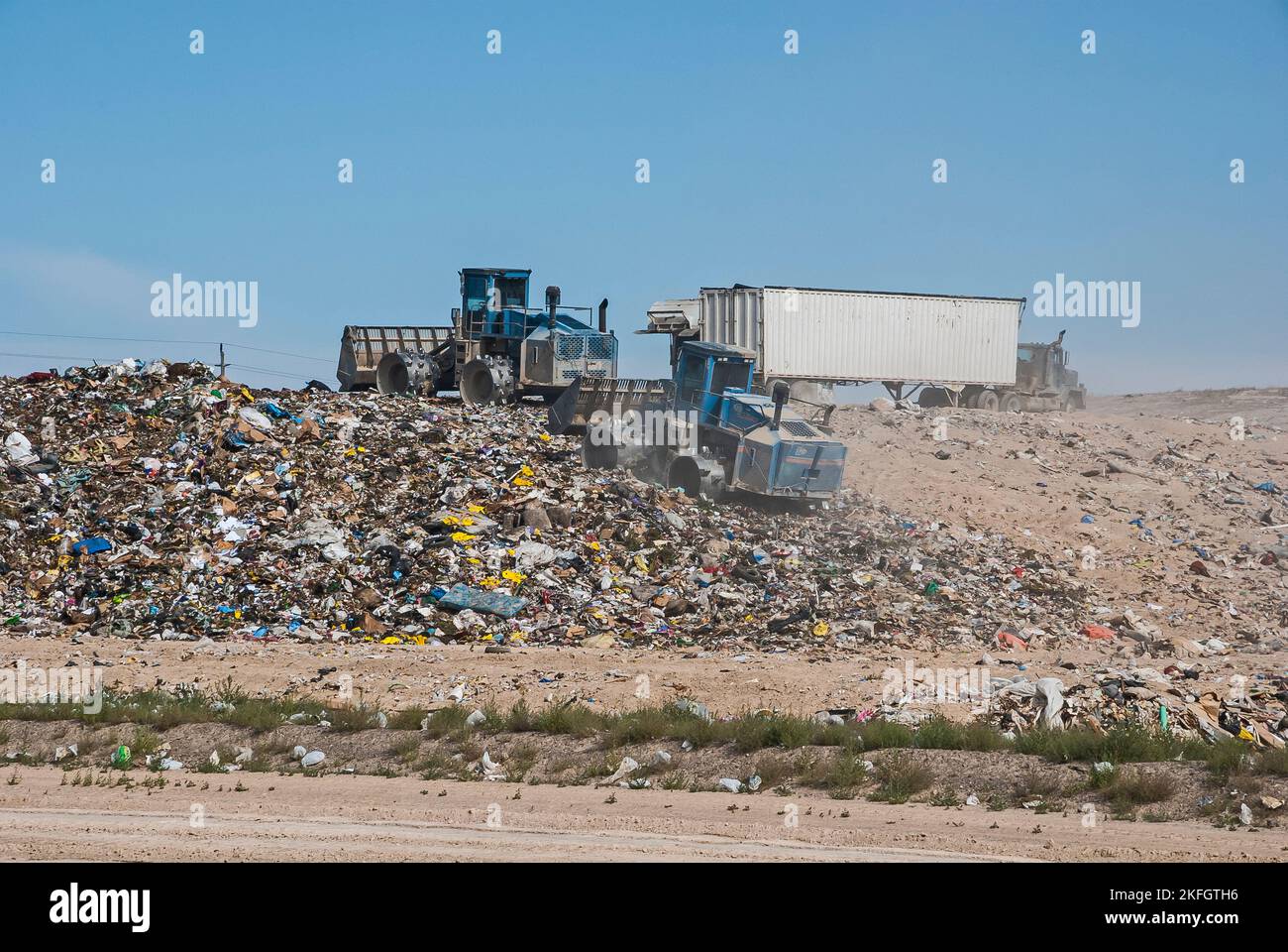 Two soil compactors and a semi tractortrailer on a hill in an active landfill Stock Photo Alamy
