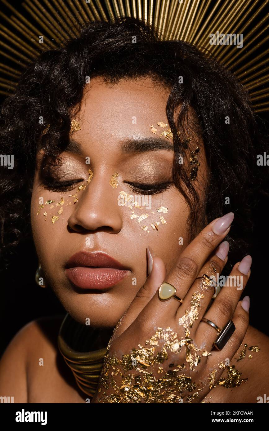 close up of young african american woman with golden necklace and paint ...