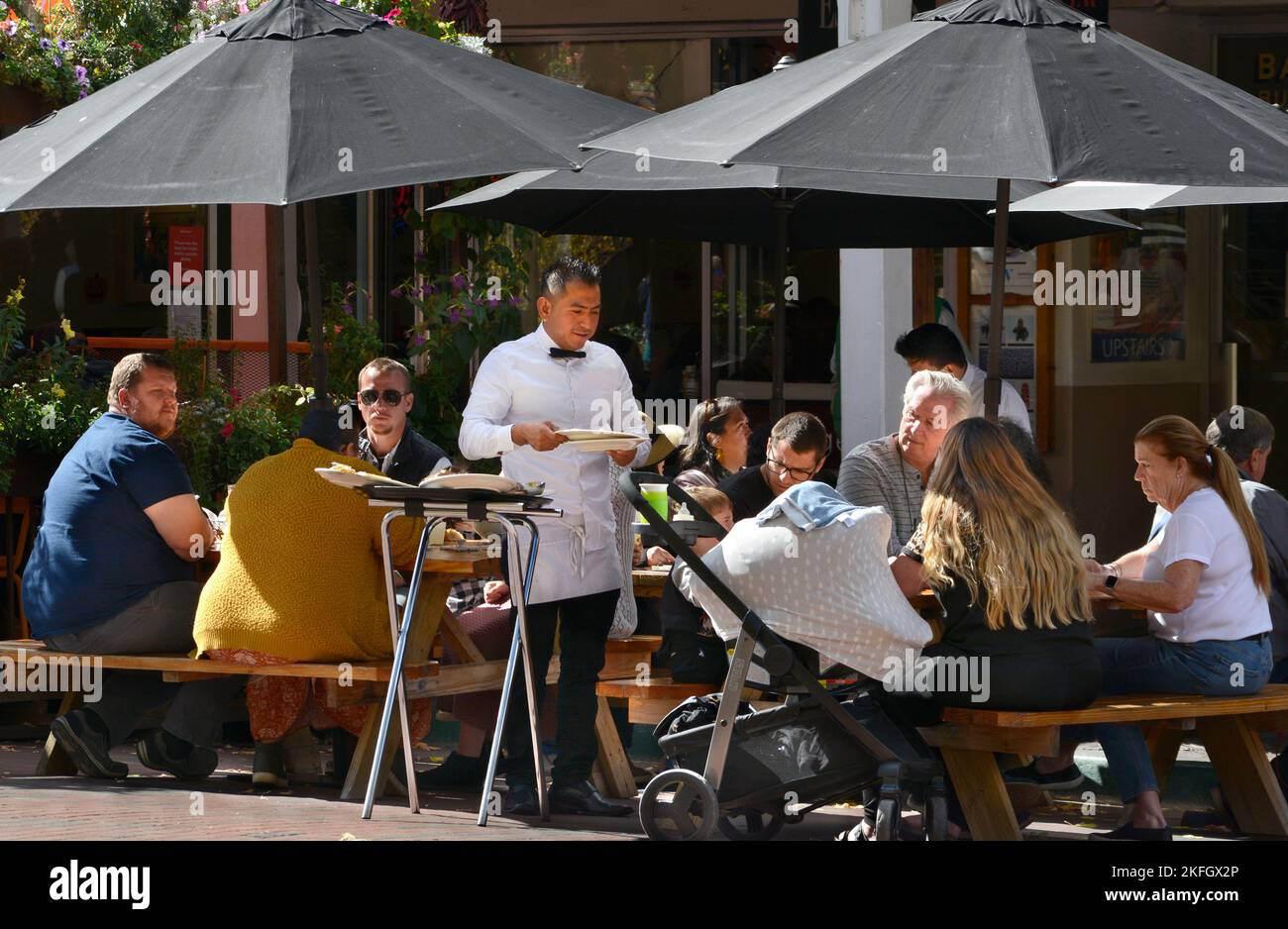 A waiter serves outdoor diners at a restaurant in Santa Fe, New Mexico. Stock Photo