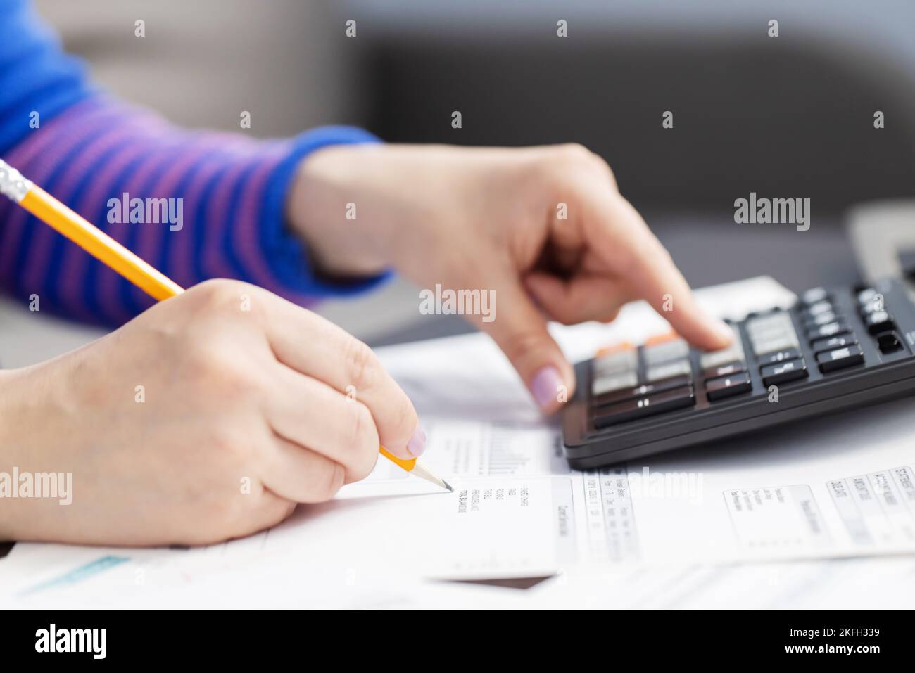 Close up young woman using calculator, managing household monthly budget Stock Photo