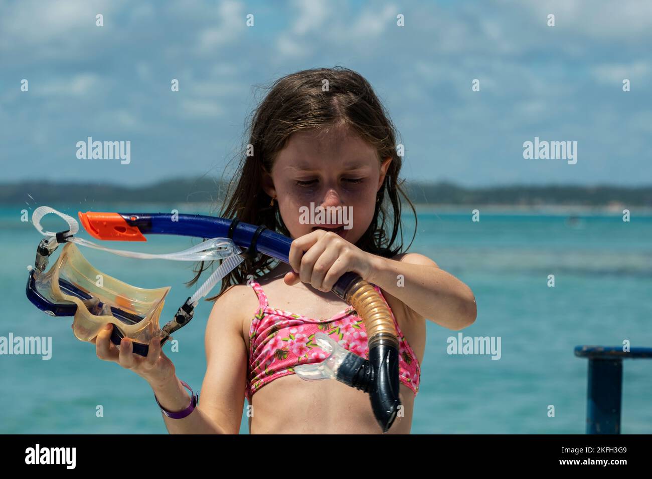 beautiful girl with snorkel in her hands with sea in the background. Stock Photo