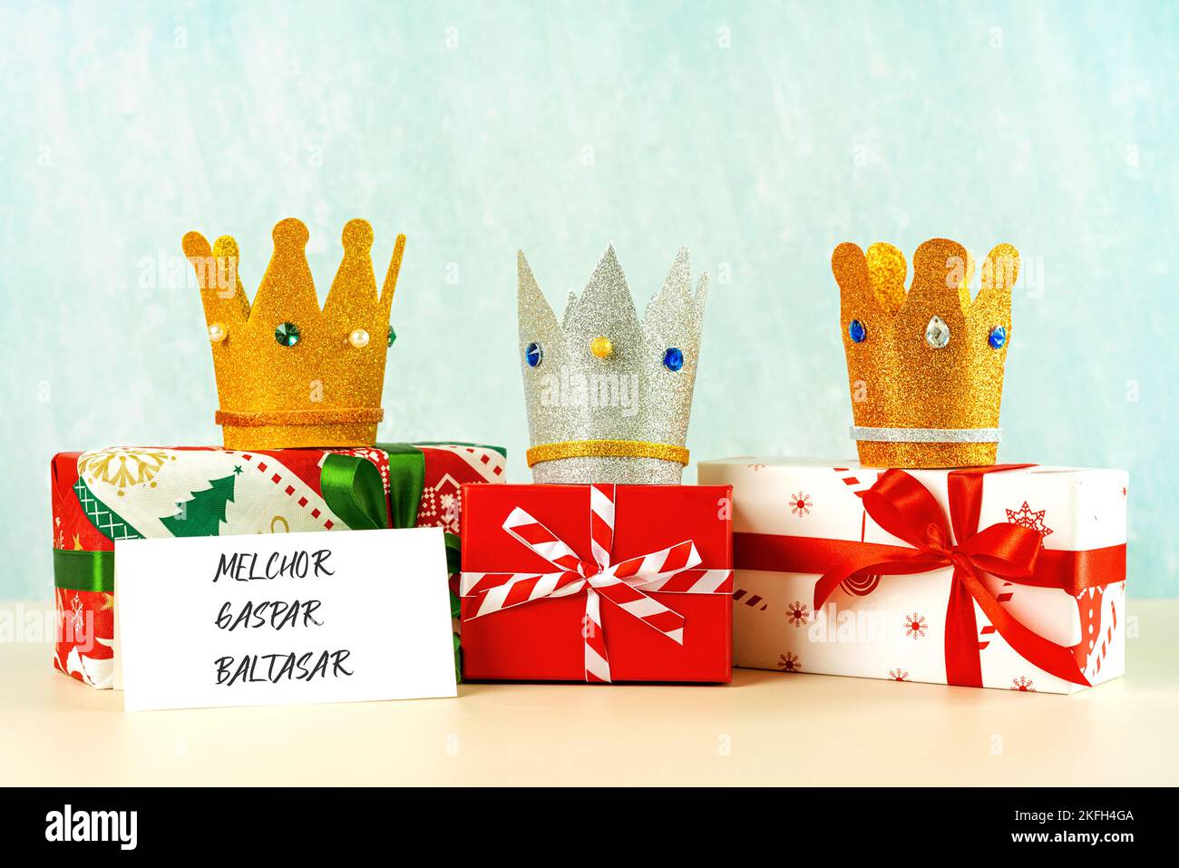 Three crowns of the three wise men with Christmas gift boxes over blue background. Concept for Dia de Reyes Magos day. Three Wise Men Stock Photo