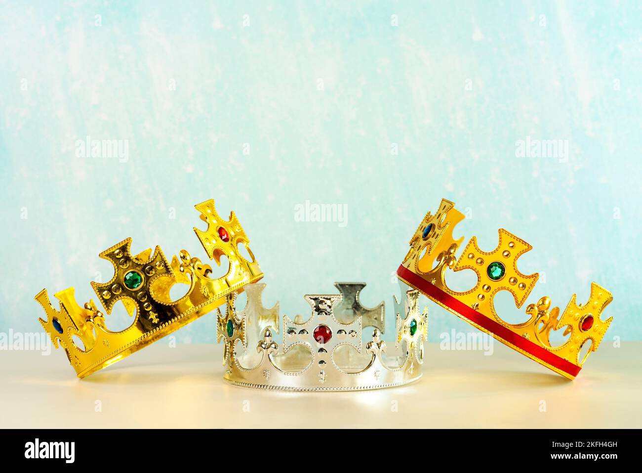 Three crowns of the three wise men with copy space over blue background. Concept for Dia de Reyes Magos day. Three Wise Men Stock Photo