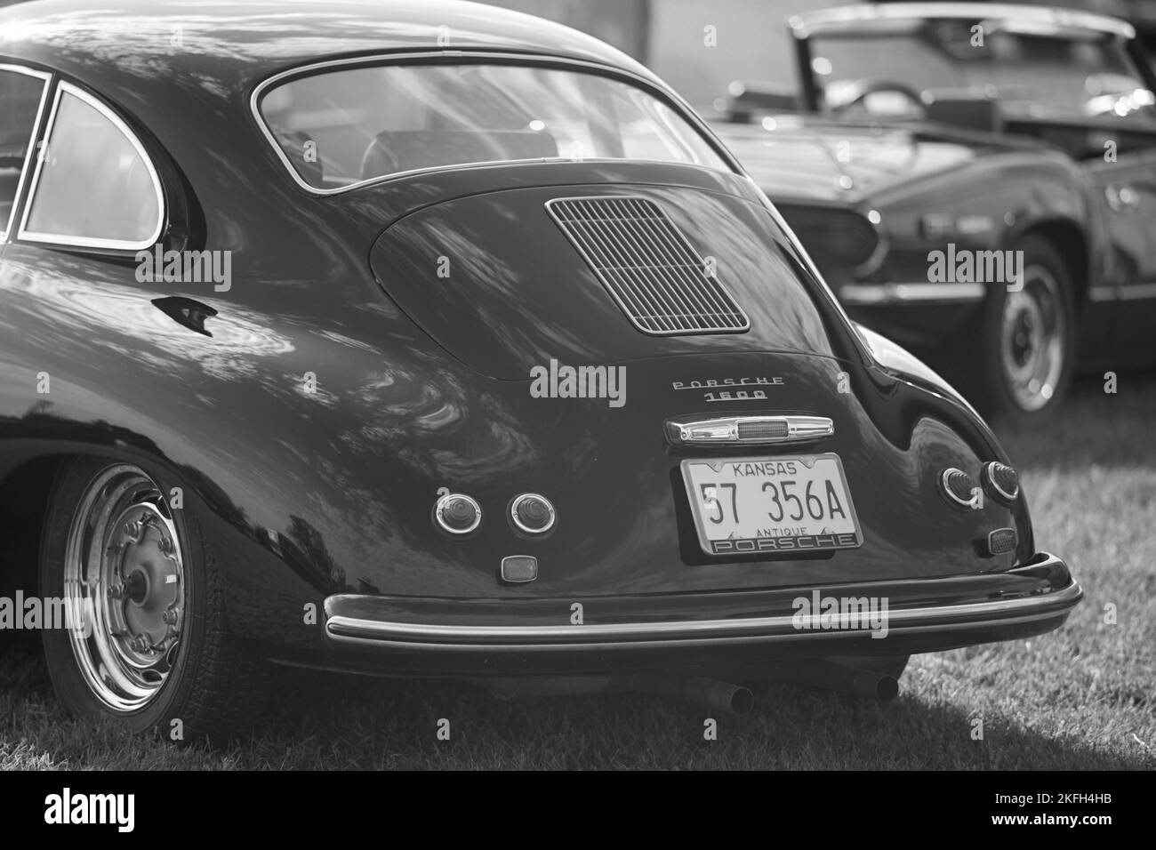 A closeup shot of a vintage Porsche 356 and MG Roadster convertible in black and white Stock Photo