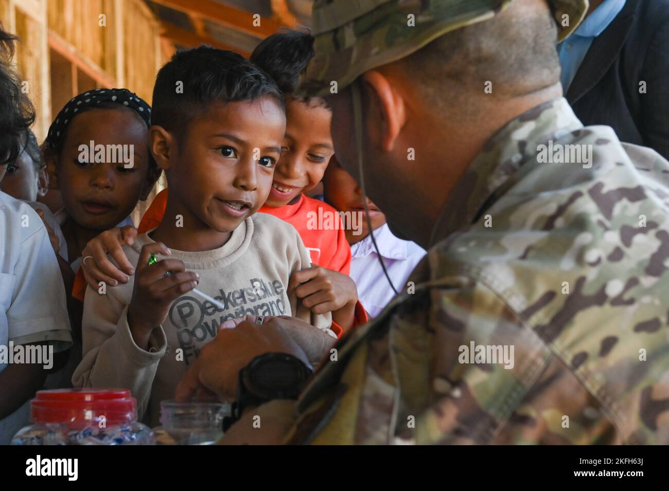 U.S. Air Force Master Sgt. Jayson Wells, lead logistician, passes out candy to children in Baucau, Timor-Leste, during a school supply donation purchased by the participants of Pacific Angel 22-4 on Sept. 16, 2022. The operation, scheduled Sept. 12-17, focuses on capacity building through health services outreach, engineering civic action program construction projects and subject matter expert exchanges. Stock Photo