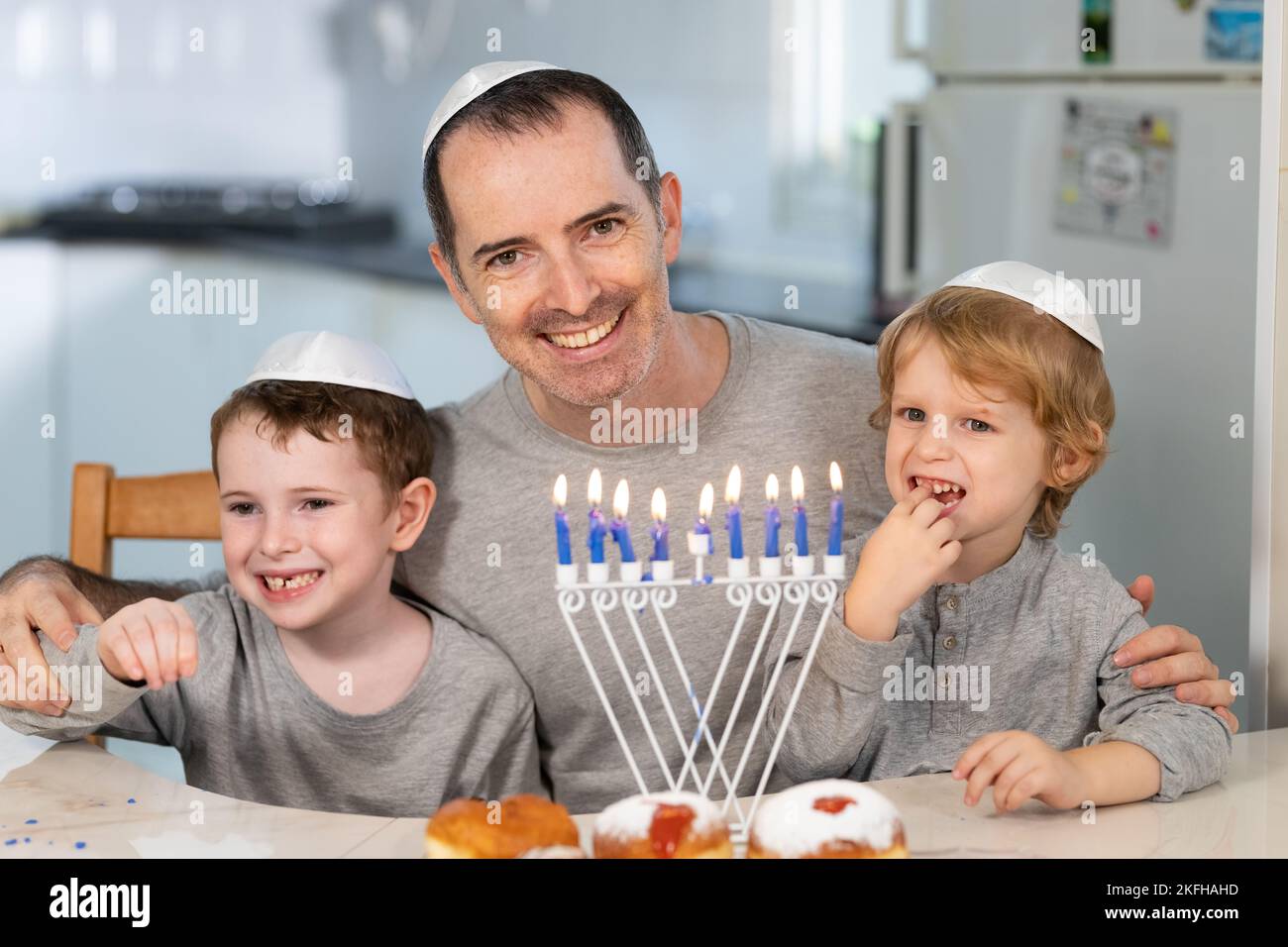 Father and sons with menorah celebrate hanukkah - Jewish religious holiday Stock Photo