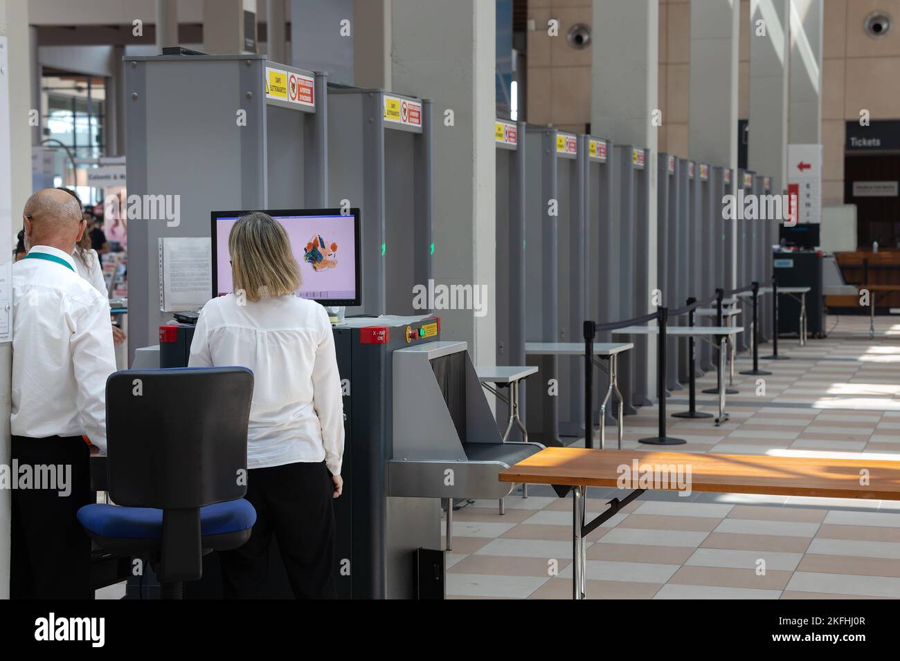 Security personnel checking bags and backpacks xrayed at the access