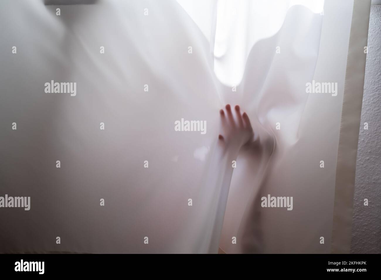 baby playing and hiding with white curtains Stock Photo