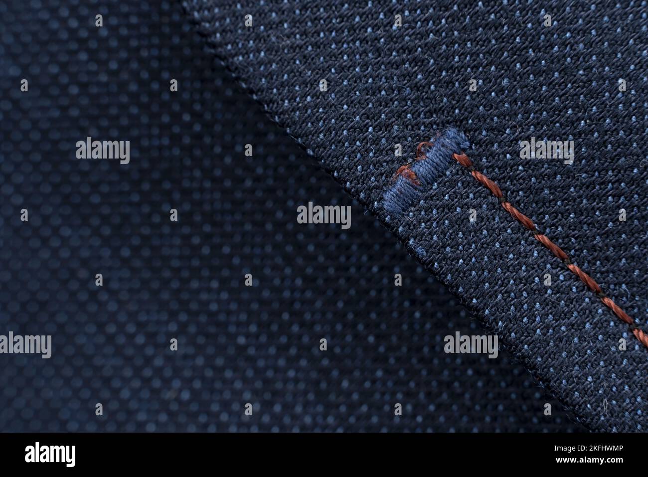 Part of a man's blue jacket pocket. Textile. Background with stitching