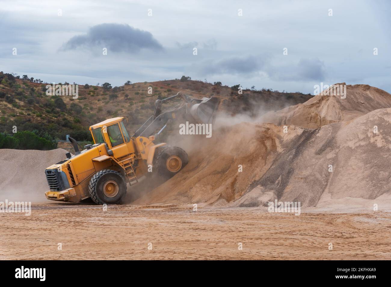Bulldozer shovel climbing a mountain of sand Stock Photo Alamy