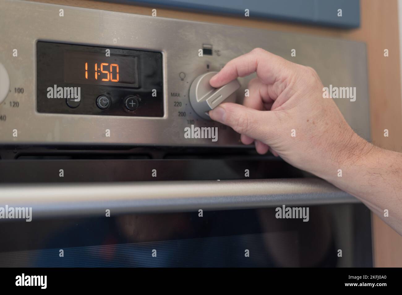 Man setting the timer clock on the oven. Turning knob to set the timer