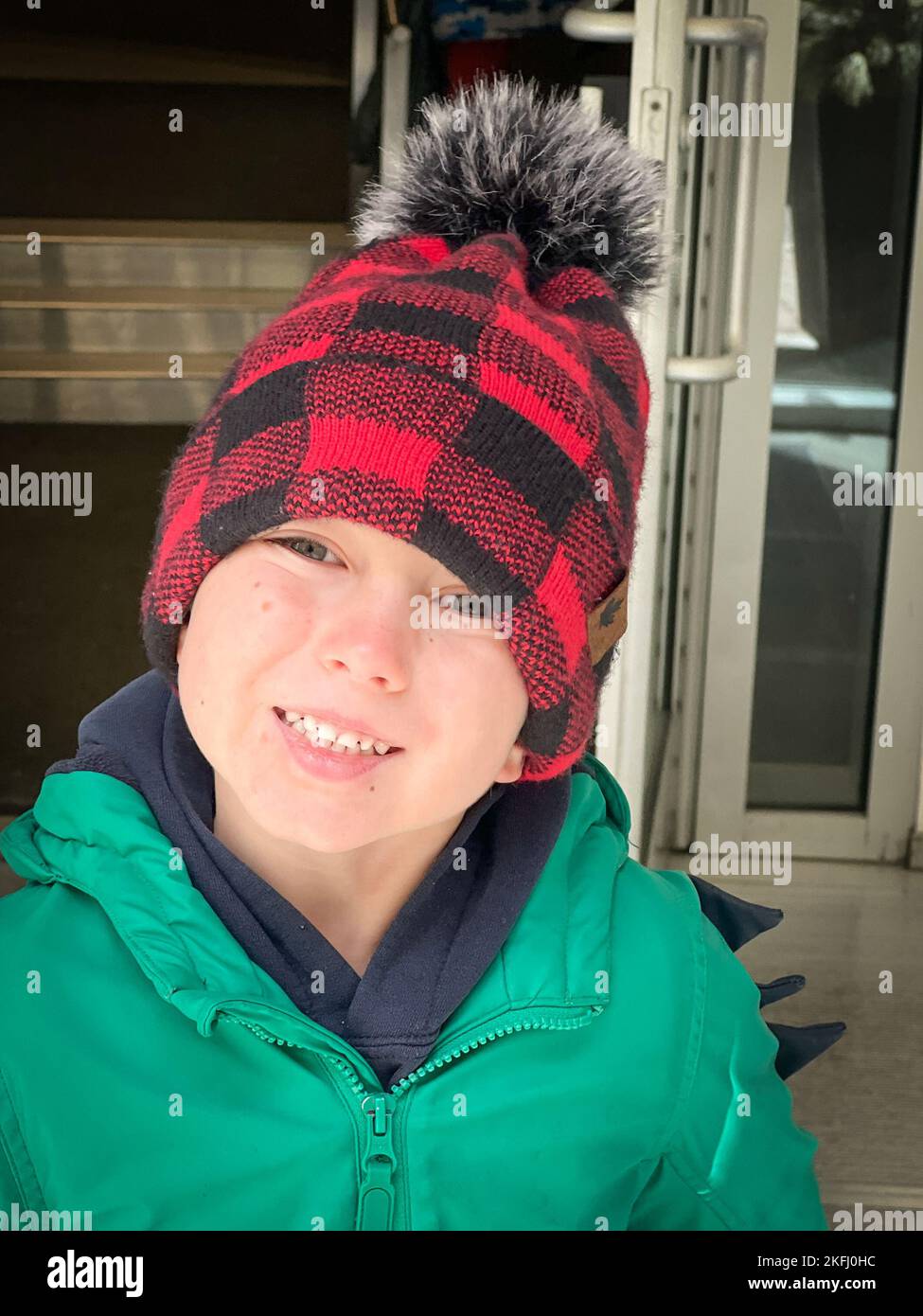Close-up portrait of cute caucasian boy wearing knit hat and winter ...