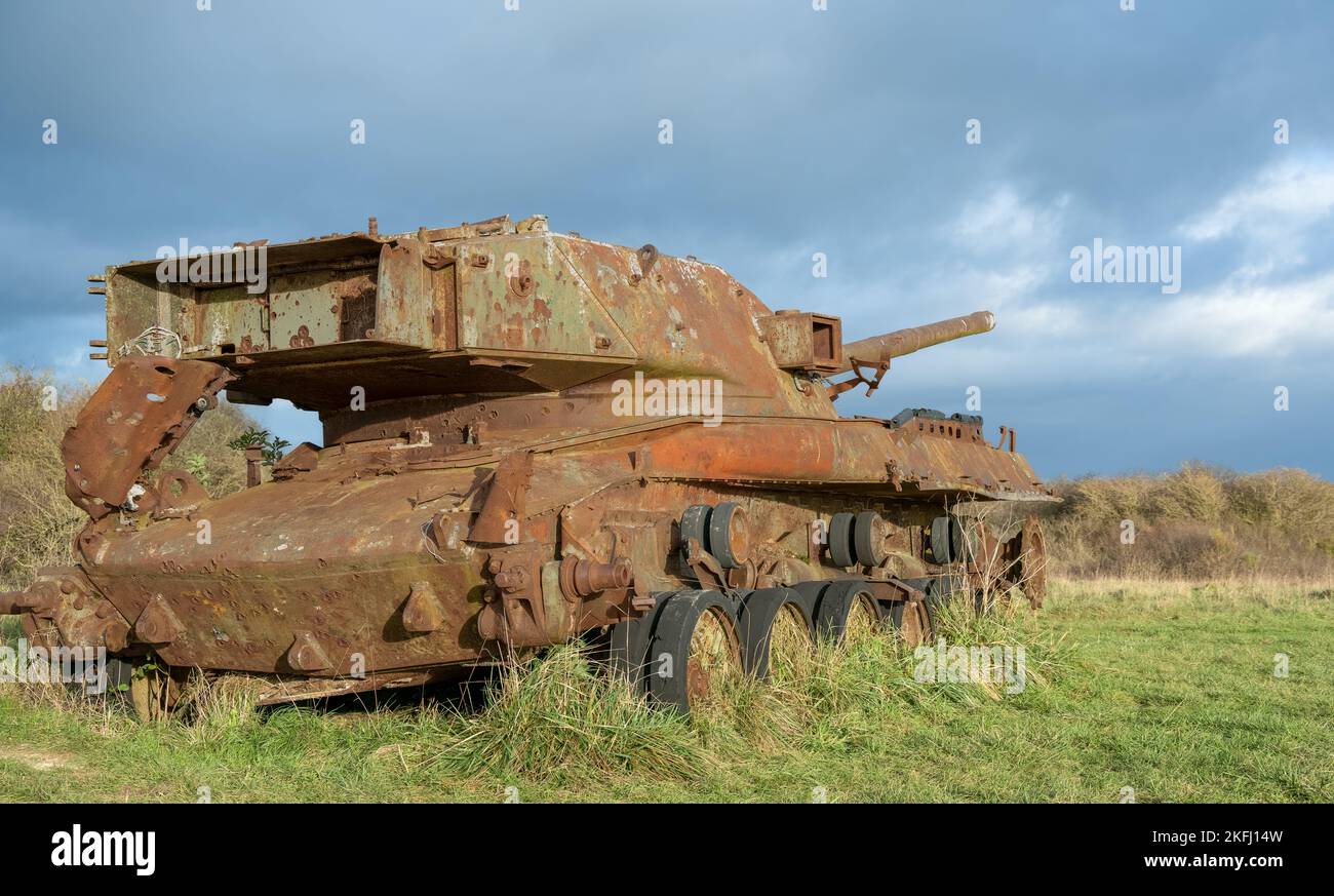 an abandoned rusting British FV4201 Chieftain main battle tank wreck in afternoon sunlight Stock Photo