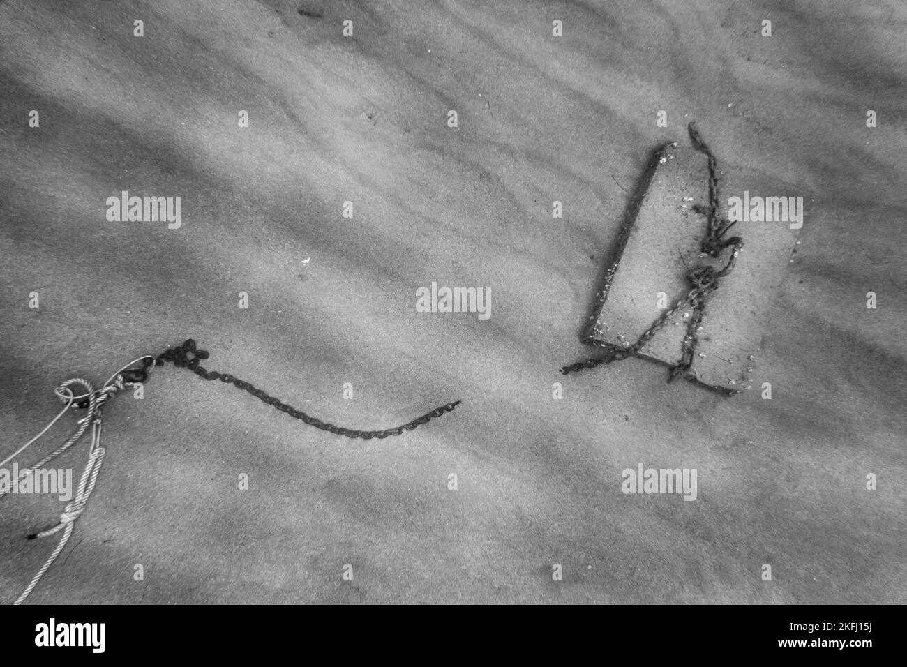 High angle view of chains tied to hook on concrete block over ocean floor undersea Stock Photo