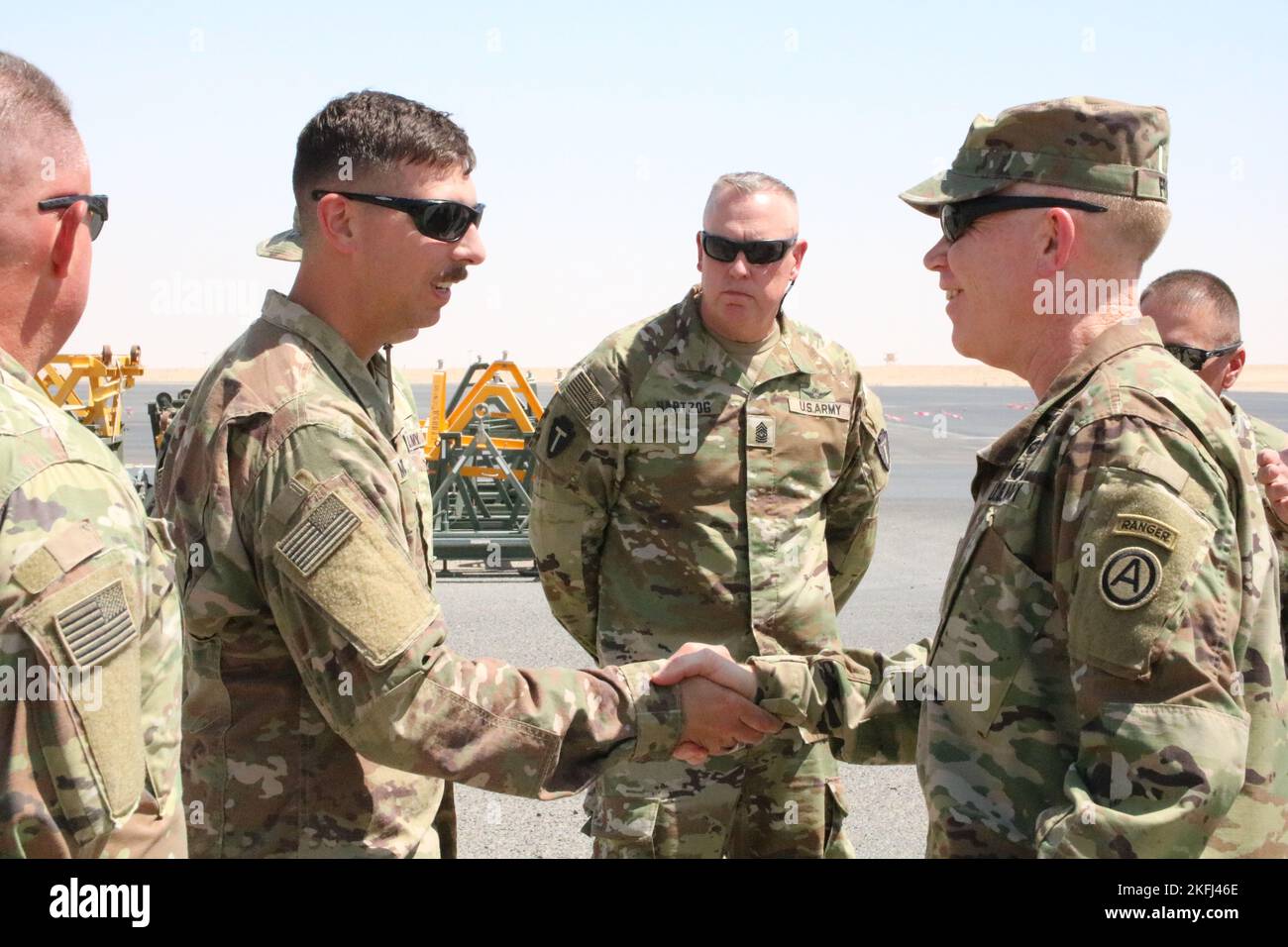 U.S. Army Lt. Gen. Patrick D. Frank, commanding general of U.S. Army Central (right), accompanied by Command Sgt. Maj. Robert W. Hartzog, command sergeant major of 36th Combat Aviation Brigade, 'Task Force Mustang' (center), receives greetings from Capt. Jacob R. McIntosh, executive officer for Bravo Company, 449th General Support Aviation Battalion, assigned as 'Task Force Dark Horse' to the 36th CAB, at Udairi Landing Zone on Camp Buehring, Kuwait, Sept. 17, 2022. 36th CAB, mobilized as Task Force Mustang, is deployed in support of the Combined Joint Task Force – Operation Inherent Resolve m Stock Photo