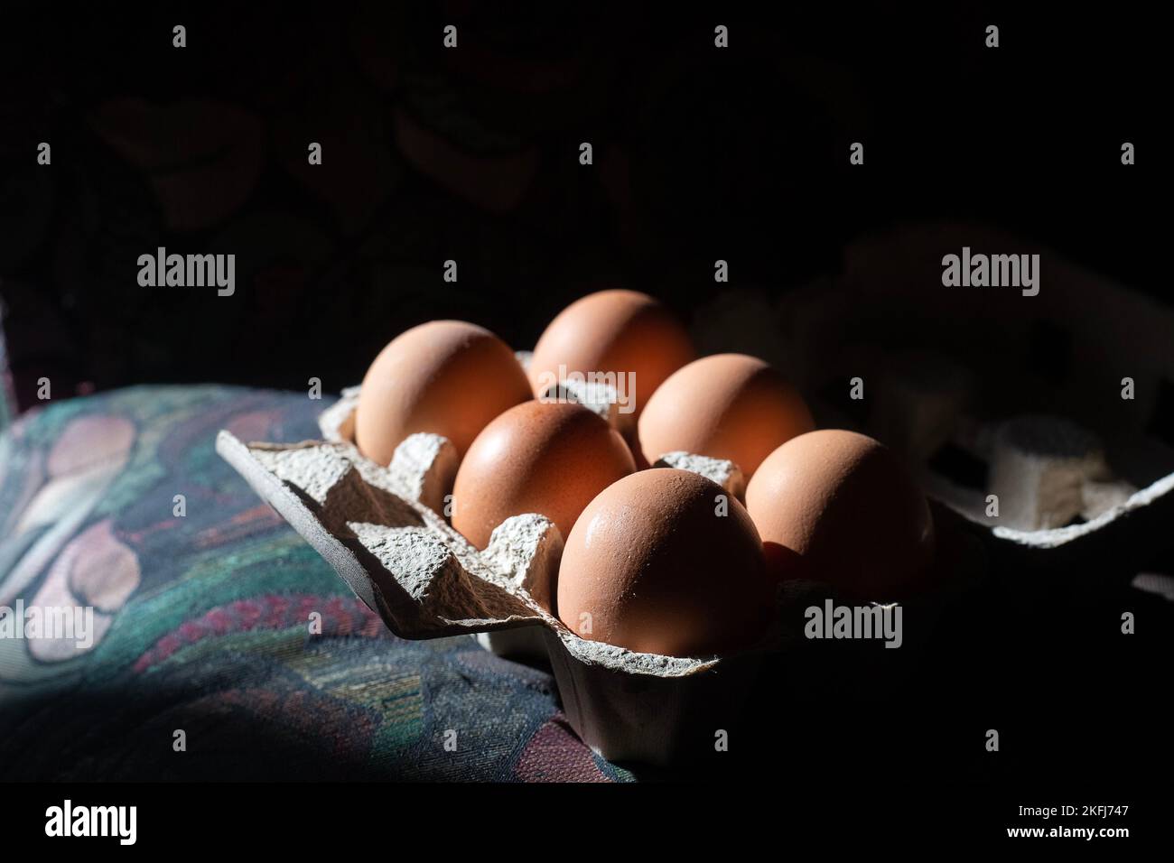 High contrast picture. Set of six brown fresh eggs in grey paper