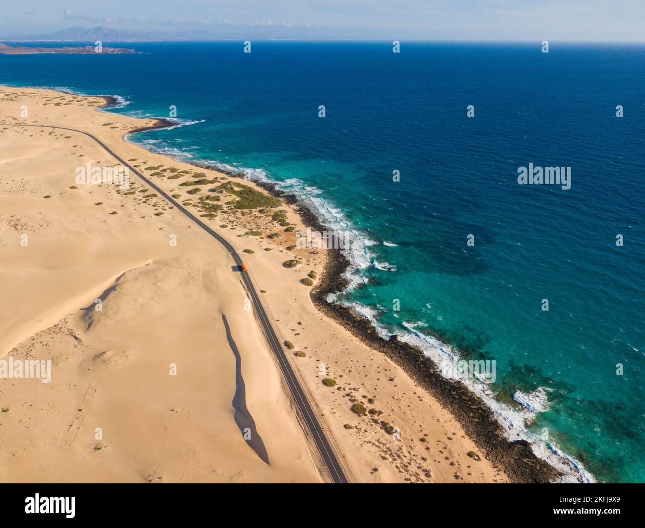 Rocky coastline and highway with golden sand and blue water, aerial view. Fuerteventura Stock Photo