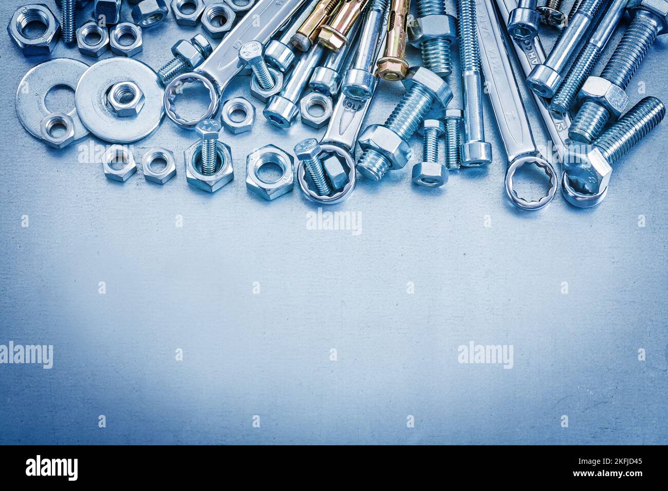 Anchor bolt washers screwbolts nuts and flat spanner on metallic background repairing concept. Stock Photo