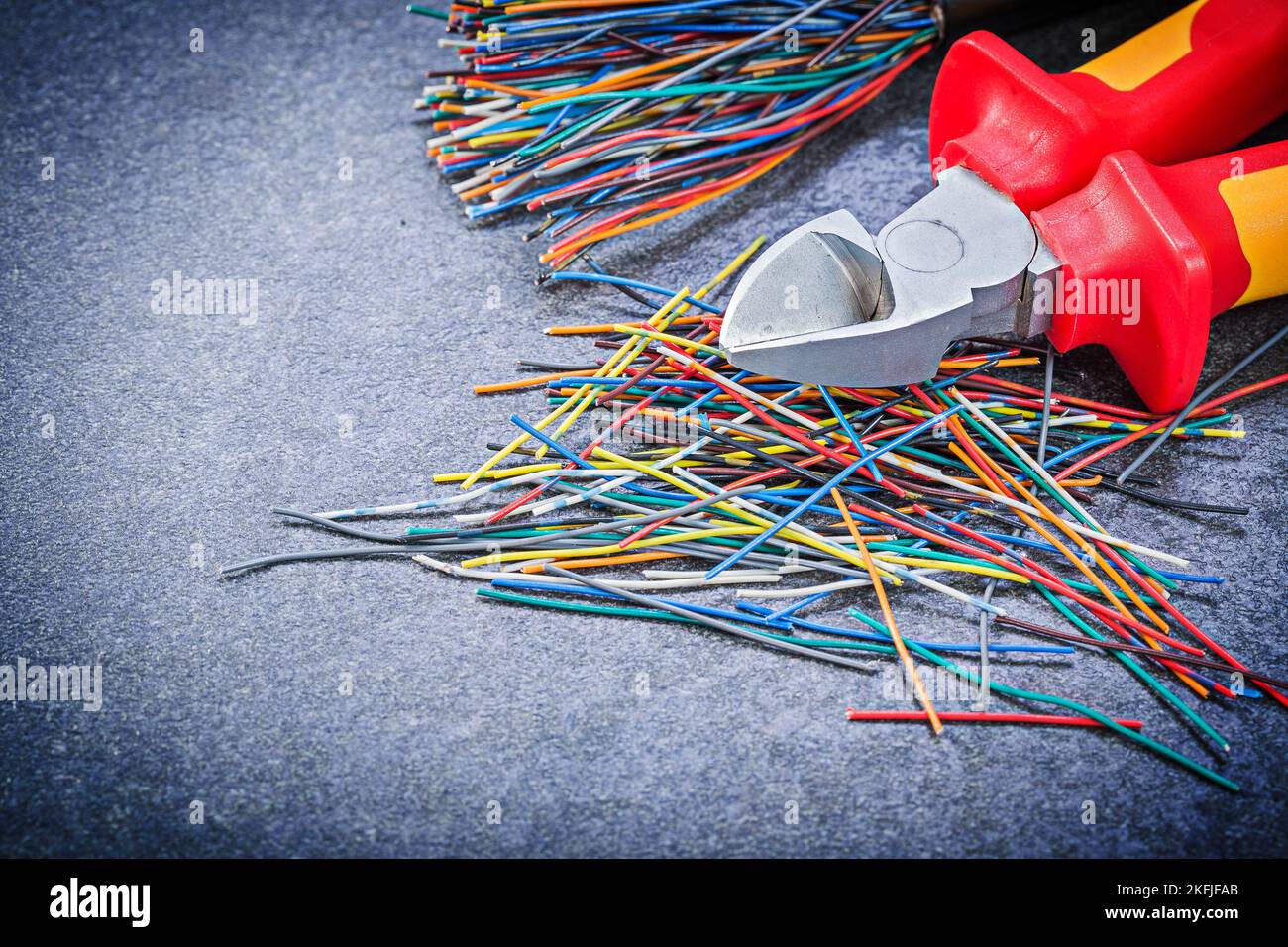Multicolored electric cables wire cutter on black background electricity concept. Stock Photo