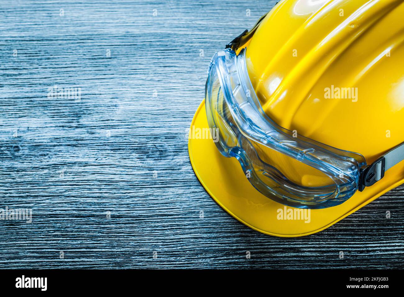 Safety cap goggles on vintage wooden board. Stock Photo
