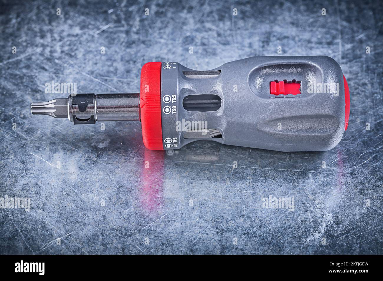 Screwdriver with replaceable bits on metallic background construction concept. Stock Photo