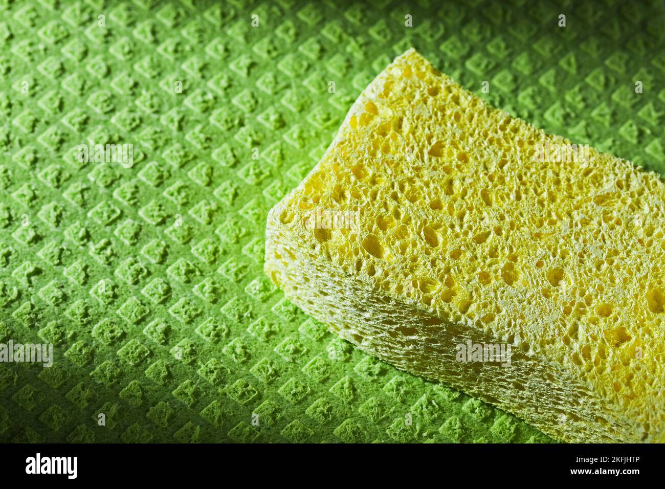 Yellow kitchen sponge on dishcloth. Stock Photo