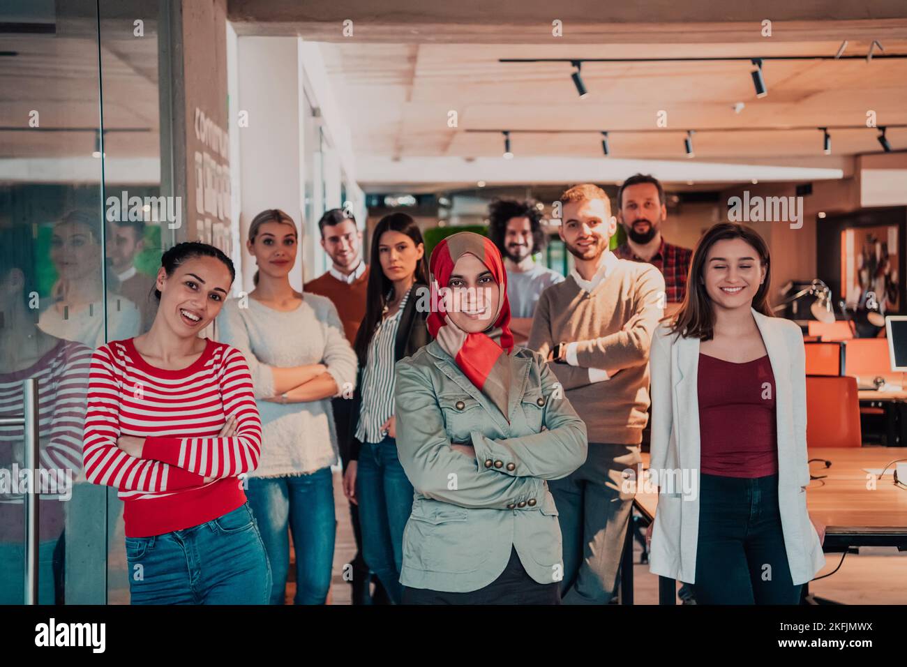 A diverse group of successful business people in a modern glass office ...