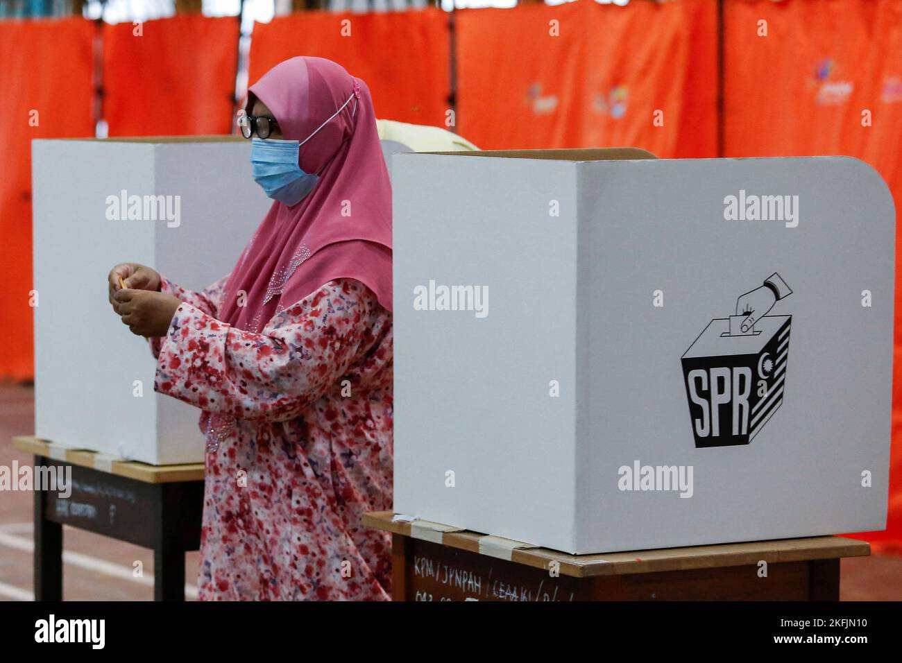 A woman casts her ballot during Malaysia's 15th general election in Bera, Pahang, Malaysia November 19, 2022. REUTERS/Lai Seng Sin Stock Photo
