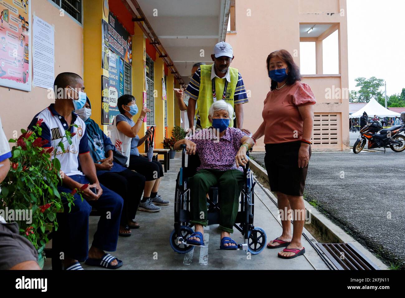 A woman arrives in a wheelchair to vote during Malaysia's 15th general election in Bera, Pahang, Malaysia November 19, 2022. REUTERS/Lai Seng Sin Stock Photo