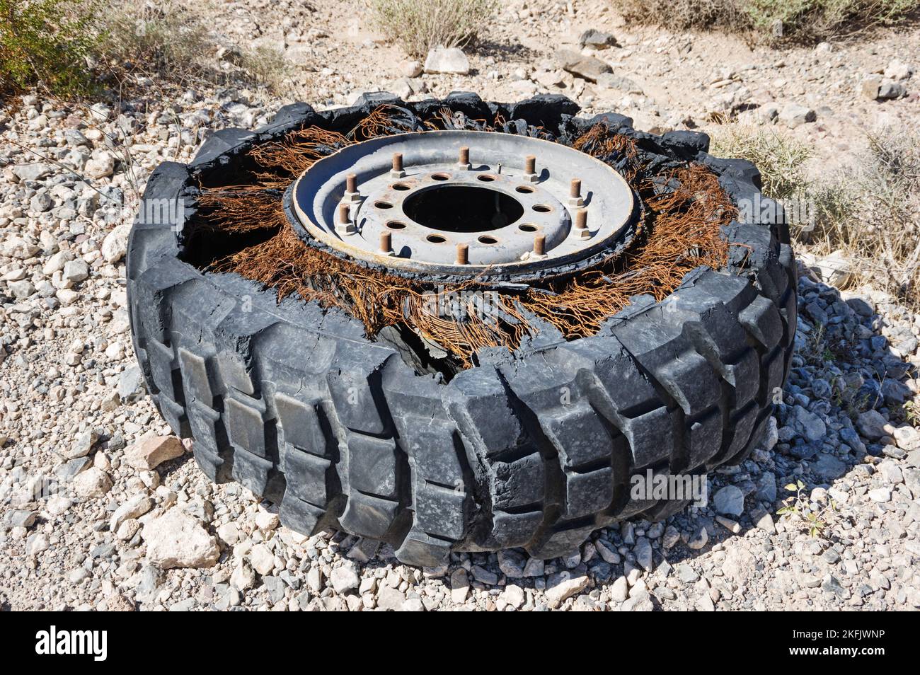 old abandoned broken truck wheel and tire in the desert with rusting