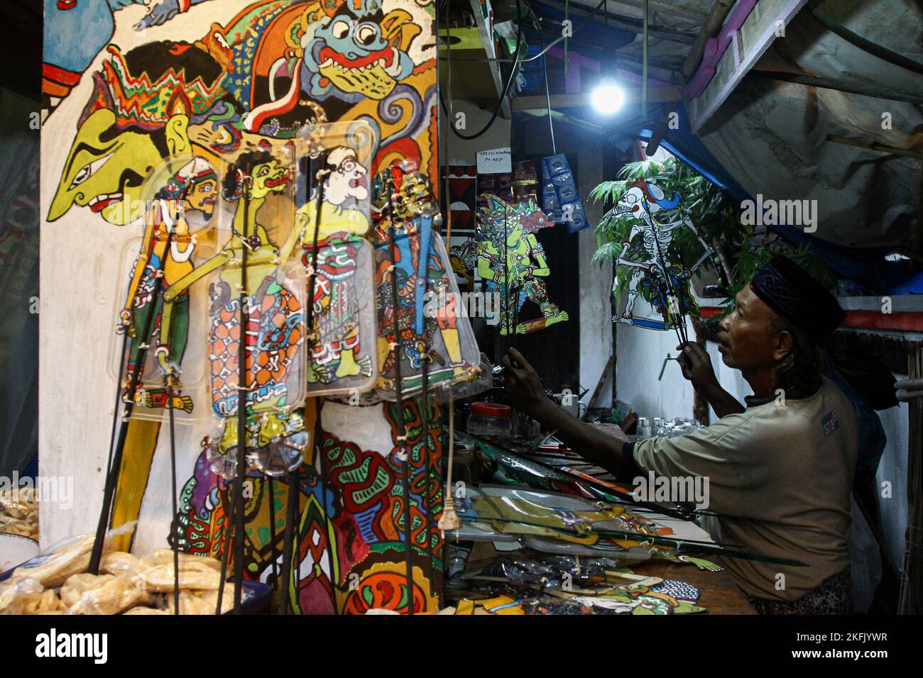 Yogyakarta, Indonesia. 16th Nov, 2022. Puppet artist Iskandar Hardjodimuljo, makes final touches on 'wayang uwuh' arts in Yogyakarta. The 'wayang uwuh', made from household waste such as used mineral water bottles, cardboard, food containers, and plastics are sold around $1.59 to $127.38. (Photo by Angga Budhiyanto/SOPA Images/Sipa USA) Credit: Sipa USA/Alamy Live News Stock Photo
