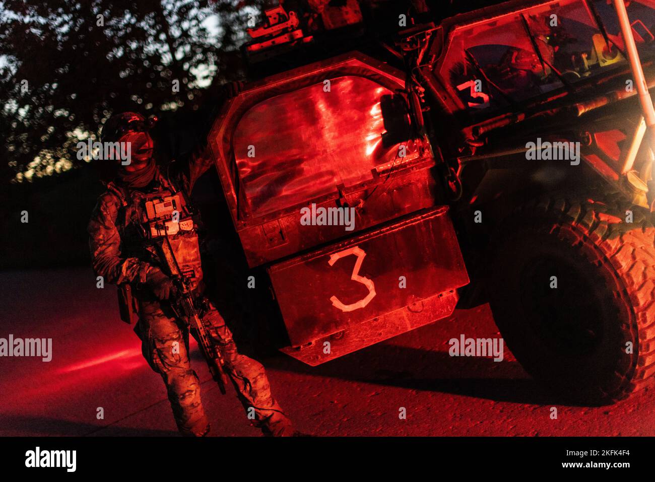 A U.S. Army Green Beret from 10th Special Forces Group (Airborne) stands beside his M1288 GMV 1.1 light utility vehicle before conducting a training mission with United Kingdom Royal Marines from 45 Commando at Grafenwöhr Training Area, Germany, Sept. 22, 2022. This Special Forces-led exercise is designed to improve their ability to work with the United Kingdom’s commando forces in a time of crisis. Stock Photo
