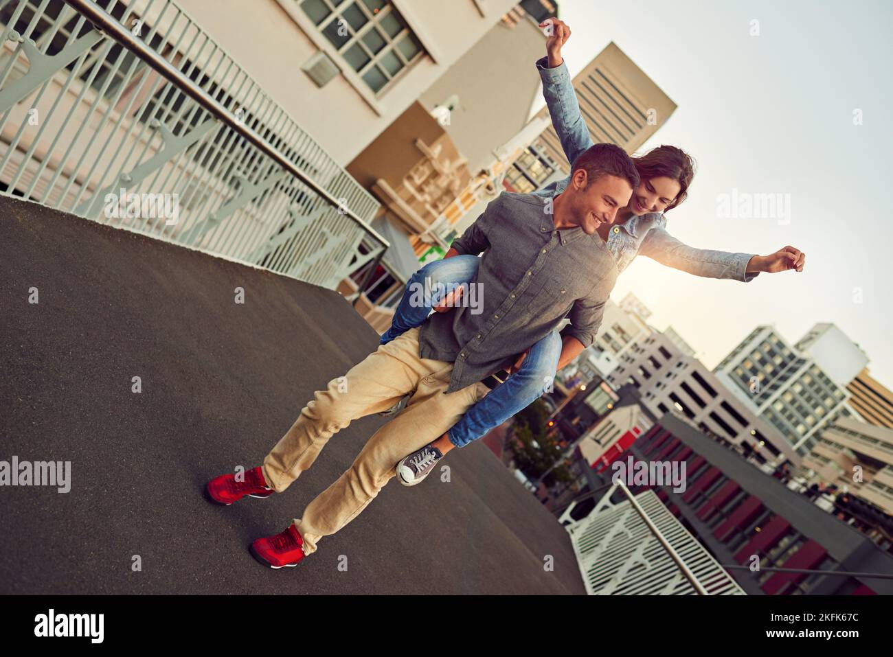 Young, in love and free. a happy young couple enjoying a piggyback ride in the city. Stock Photo