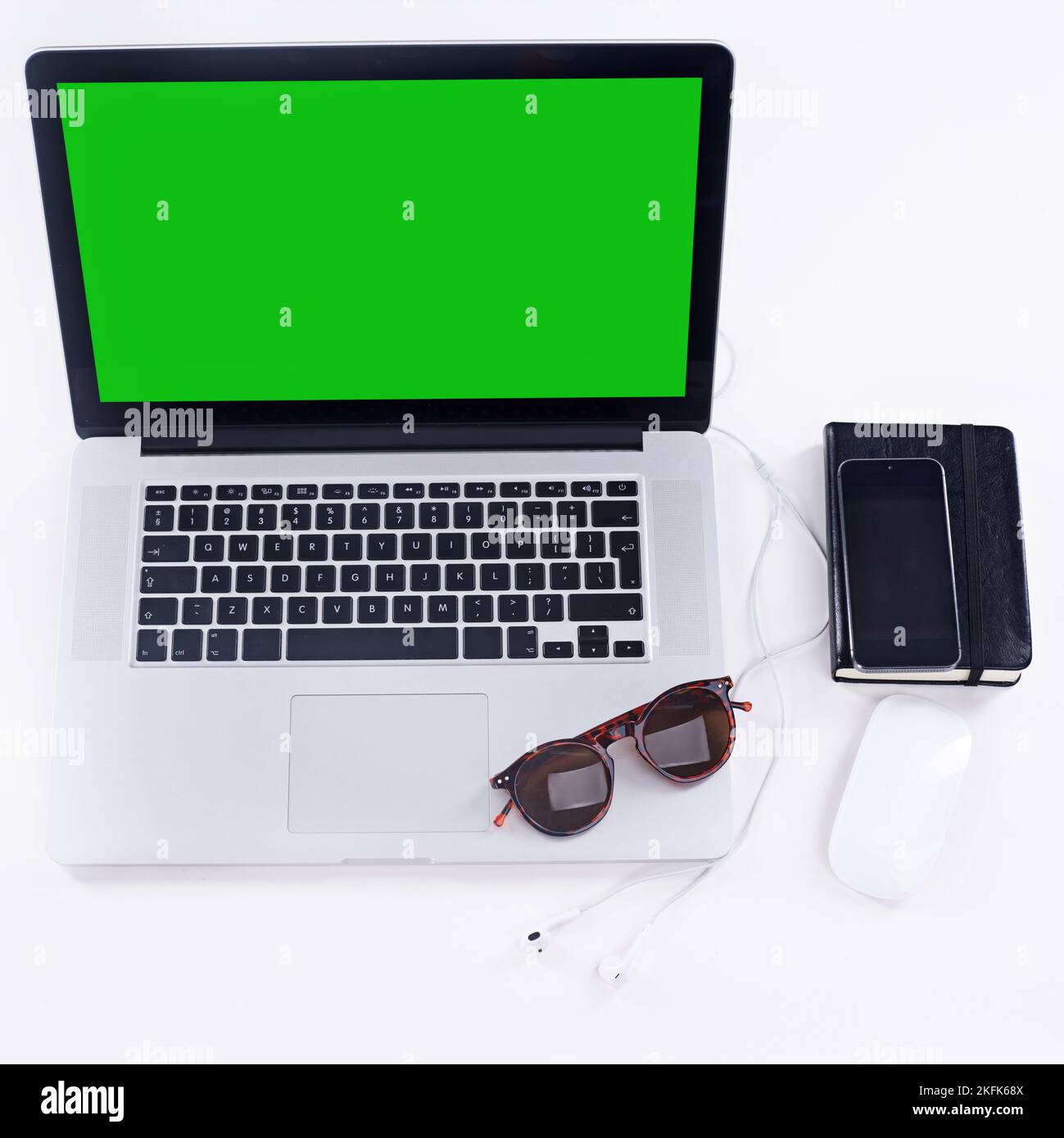 Get blogging. a laptop, glasses, mouse and notebook on a table. Stock Photo