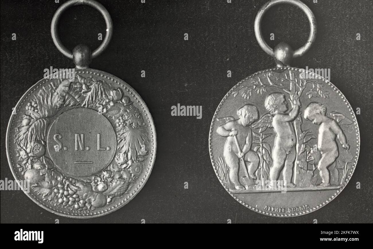 New York City - Medal of the School Nature League , 1921. Front and back of medal, with cherubs gardening and name Alphe&#xb4;e DuBois on one side and the initials S.N.L. on the other. Stock Photo