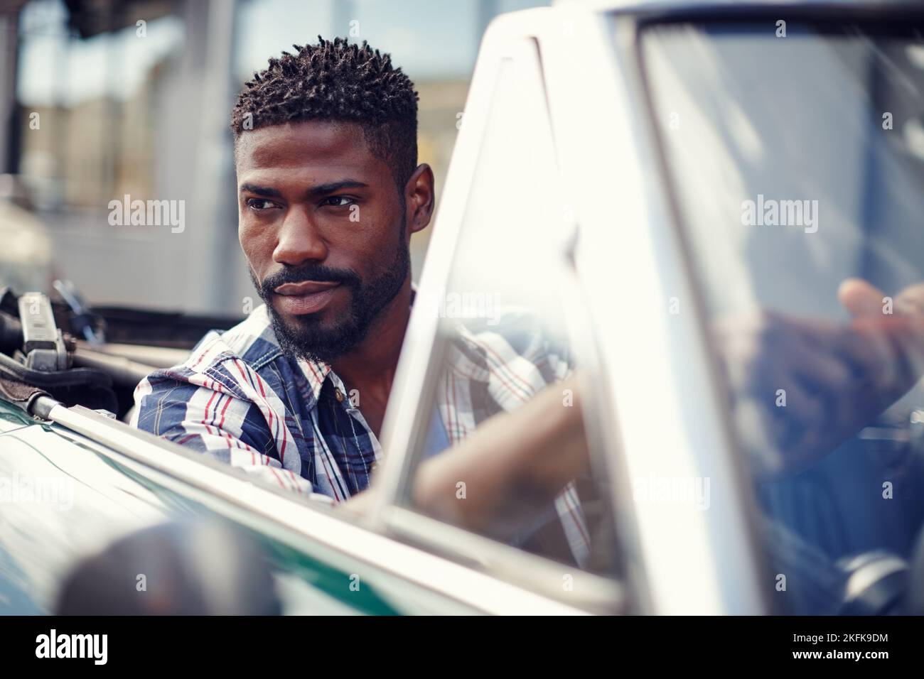 Make a powerful statement. A handsome young man driving in his convertible. Stock Photo