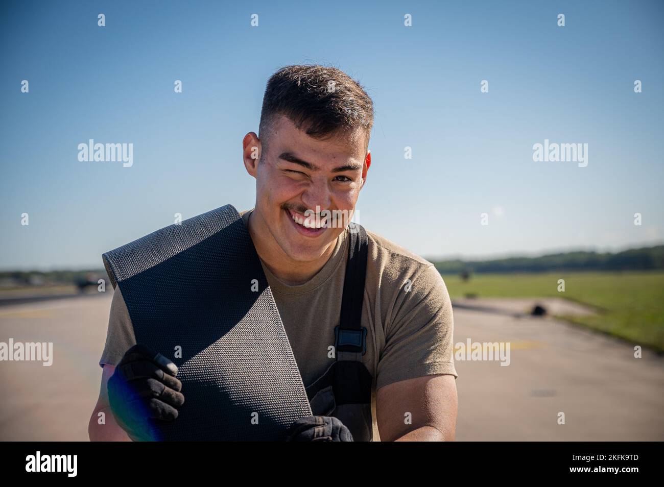 Airman First Class Juan Mejia, 86th Civil Engineer Squadron electrical power production apprentice, carries nylon tape for the Barrier Arresting Kit-12 during the system overhaul at Ramstein Air Base, Germany, Sept. 22, 2022. The system acts as a mechanical barrier capable of rapidly decelerating any landing aircraft with a tail hook. Stock Photo