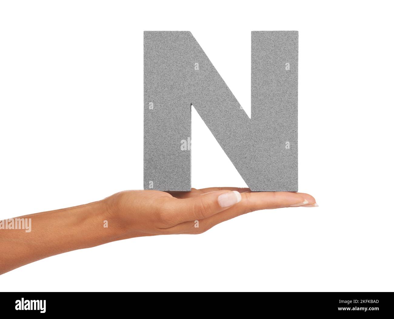 An N just for you. A young woman holding a capital letter N isolated on a white background. Stock Photo