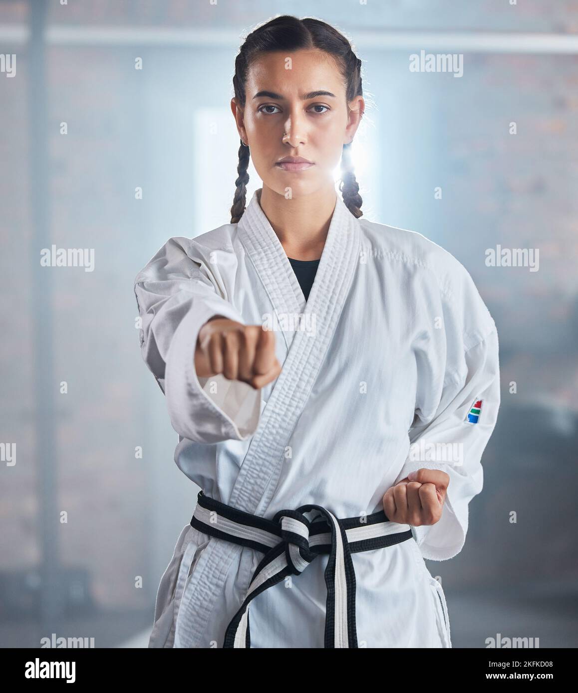 Woman, karate and punching pose in taekwondo fitness, workout or training for black belt competition, fight challenge or self defense. Portrait Stock Photo