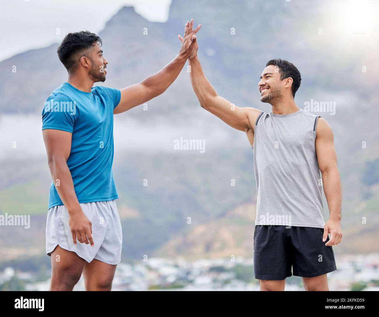 High five, man and friends for outdoor fitness in summer, sport and happy by mountain. Teamwork, support and hands together in success, wellness or Stock Photo