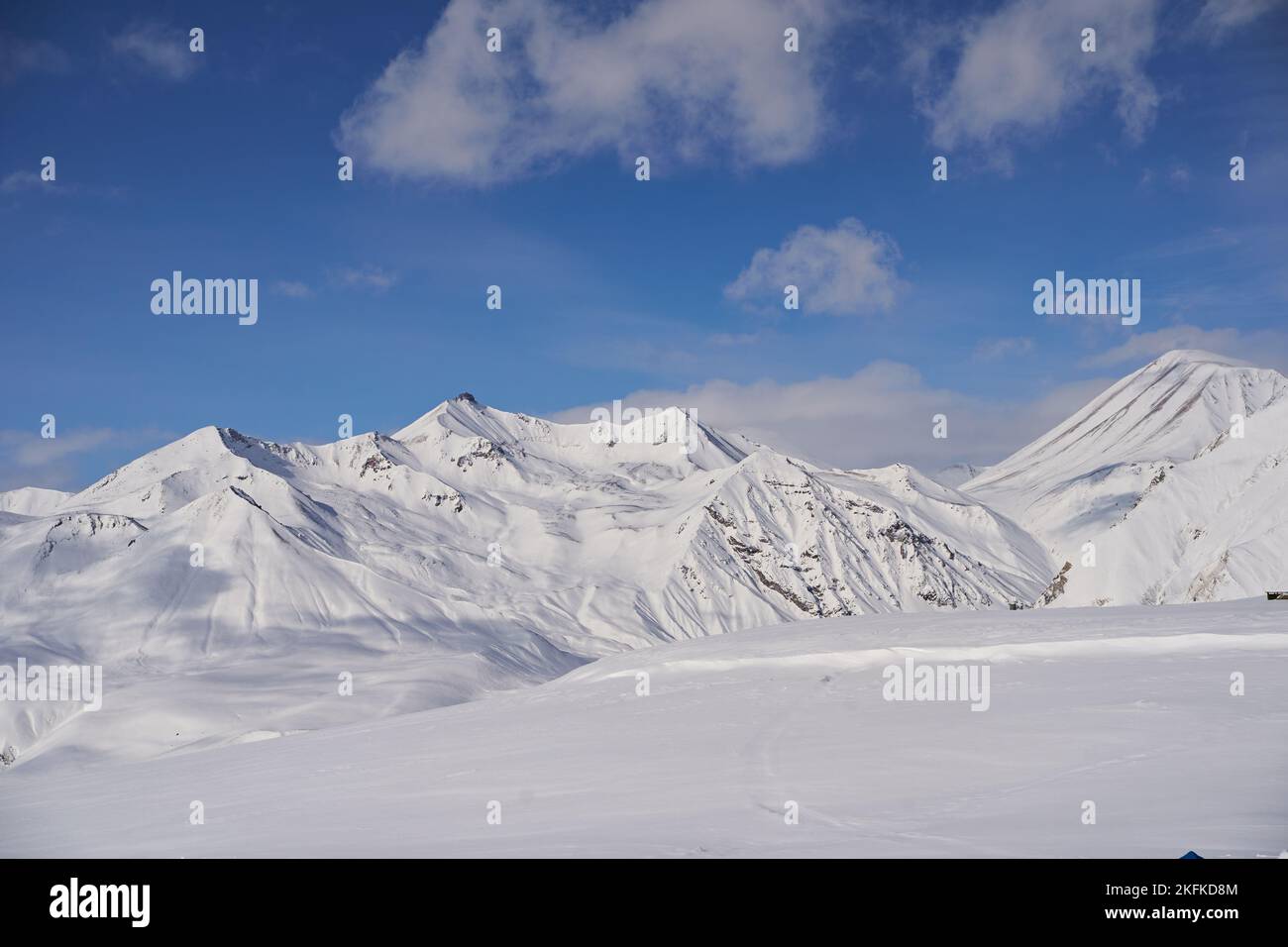 Aerial of snowy mountain slopes full of powder for freeride at ski