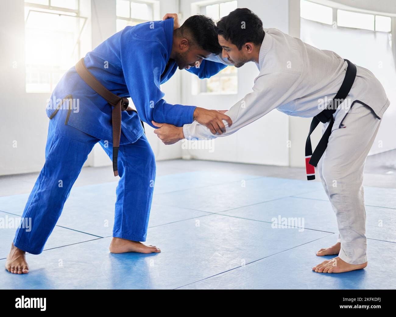 Karate, martial arts and men fighting in dojo for sports and health with discipline and balance in battle. Fitness, workout and exercise, mental Stock Photo