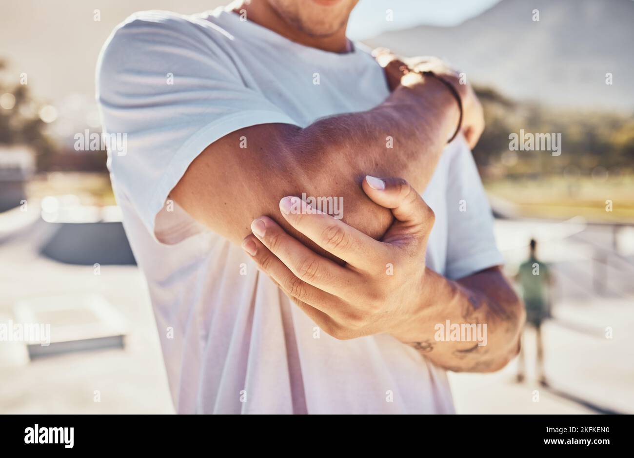 Elbow, joint pain and man, outdoor accident and urban park, emergency and first aid, risk and body problem. Broken arm, bone health and guy in pain Stock Photo