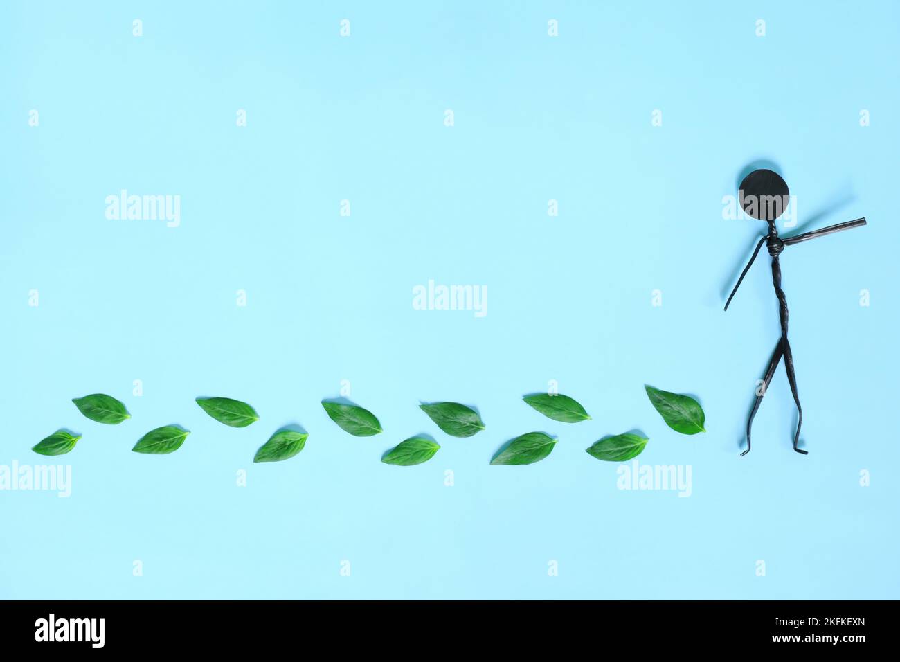 Environment friendly, sustainable, ecological lifestyle living and carbon footprint reduction concept. Stick figure man with fresh green leaves Stock Photo
